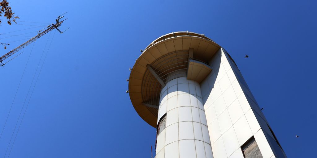 A tower reaches high towards the blue sky.