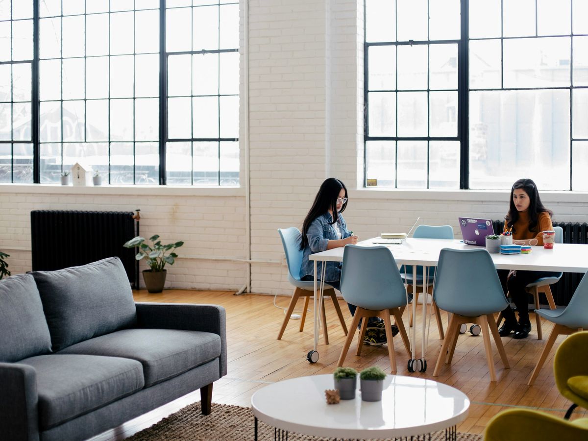 two women sitting in front of white table