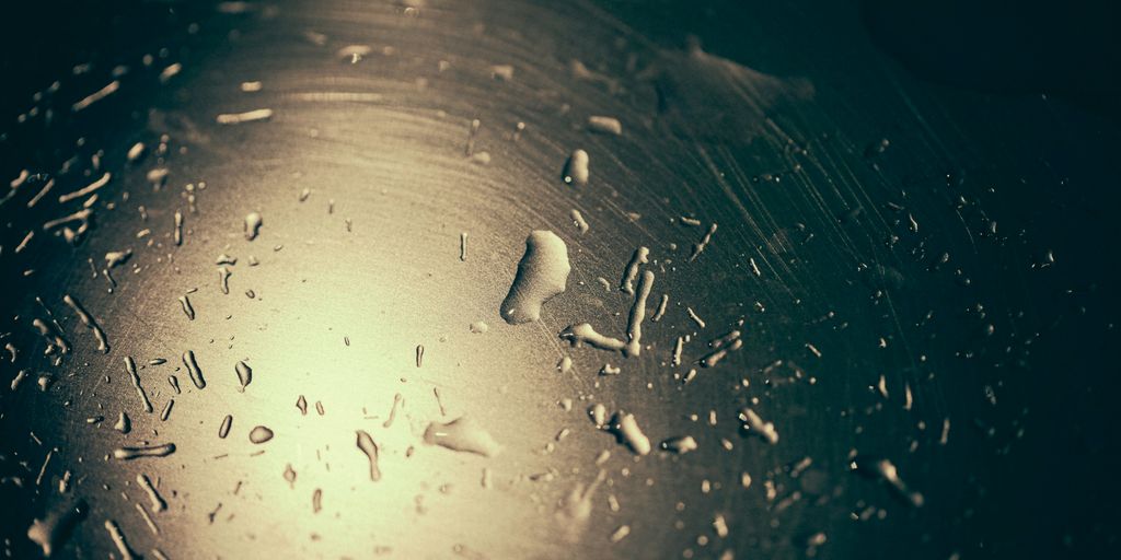 Water droplets create a reflective pattern on a surface.