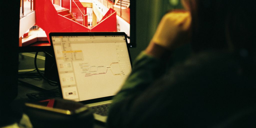 person wearing black jacket in front of flat screen computer monitor