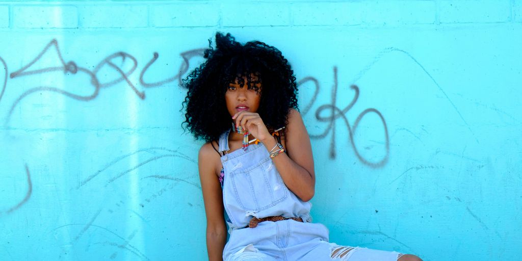 woman leaning on blue wall