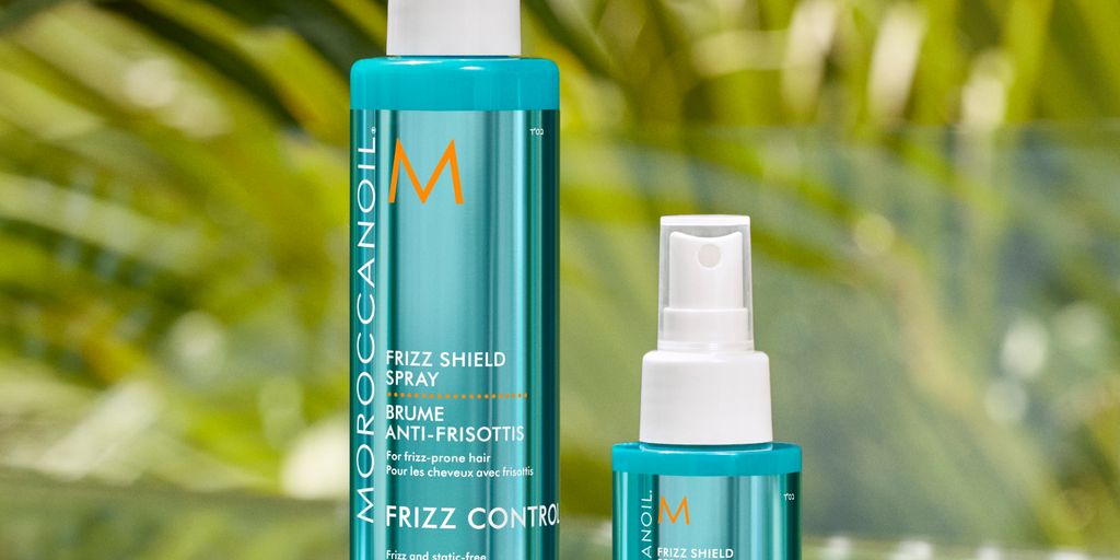 Hair care products displayed with a tropical foliage background.