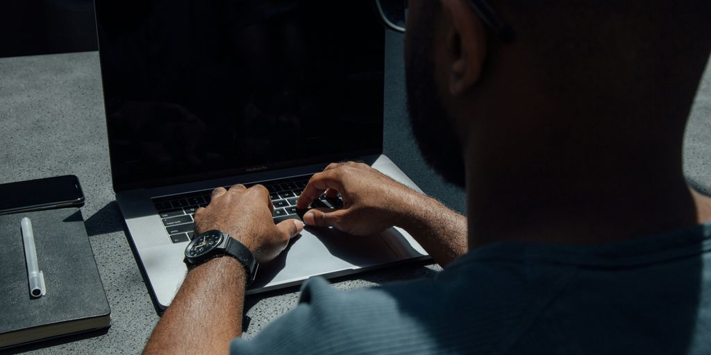 man using laptop computer on desk