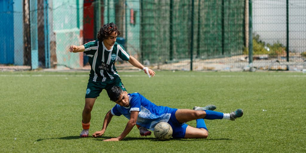 A soccer player makes a tackle on the field.