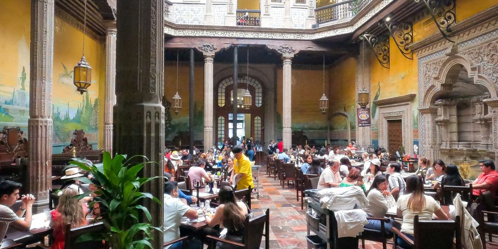 a restaurant filled with lots of people sitting at tables