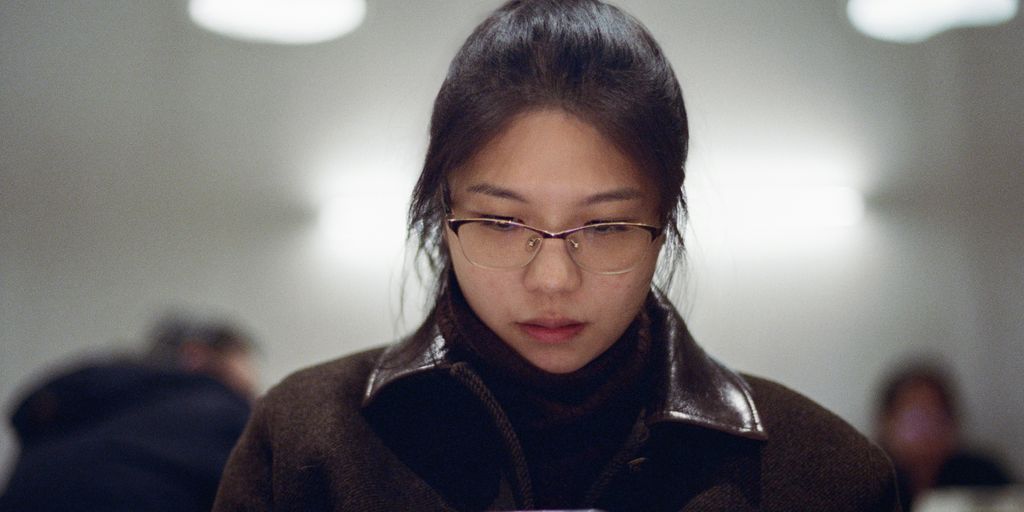 A woman looking at her cell phone in a public place