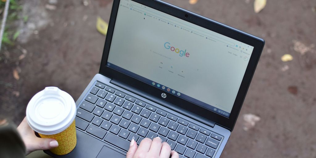 a person using a laptop computer with a cup of coffee