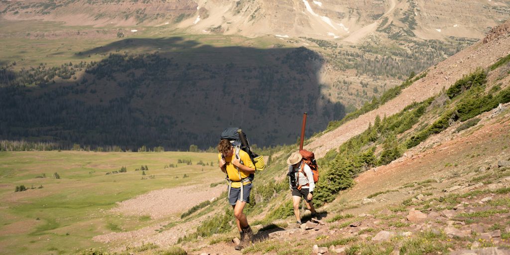 A couple of people that are walking up a hill