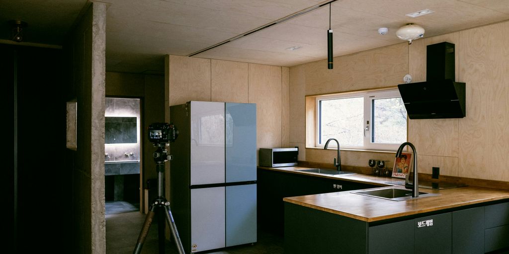 a kitchen with a sink a refrigerator and a tripod