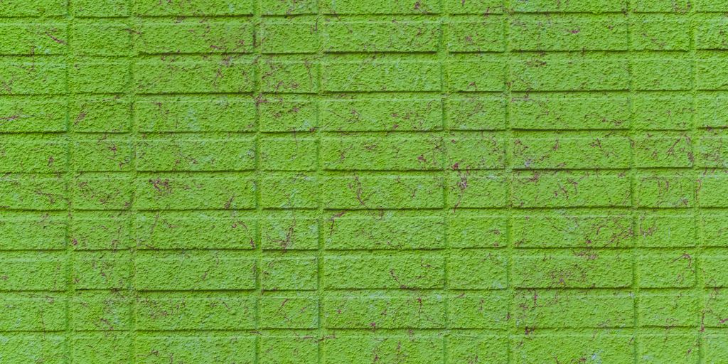 a green brick wall that has been painted green