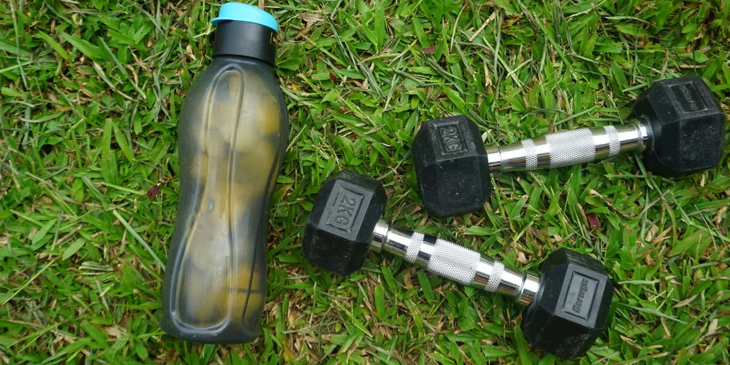 2 black and gray dumbbells on green grass