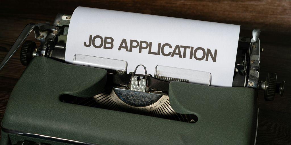 a typewriter with a job application printed on it
