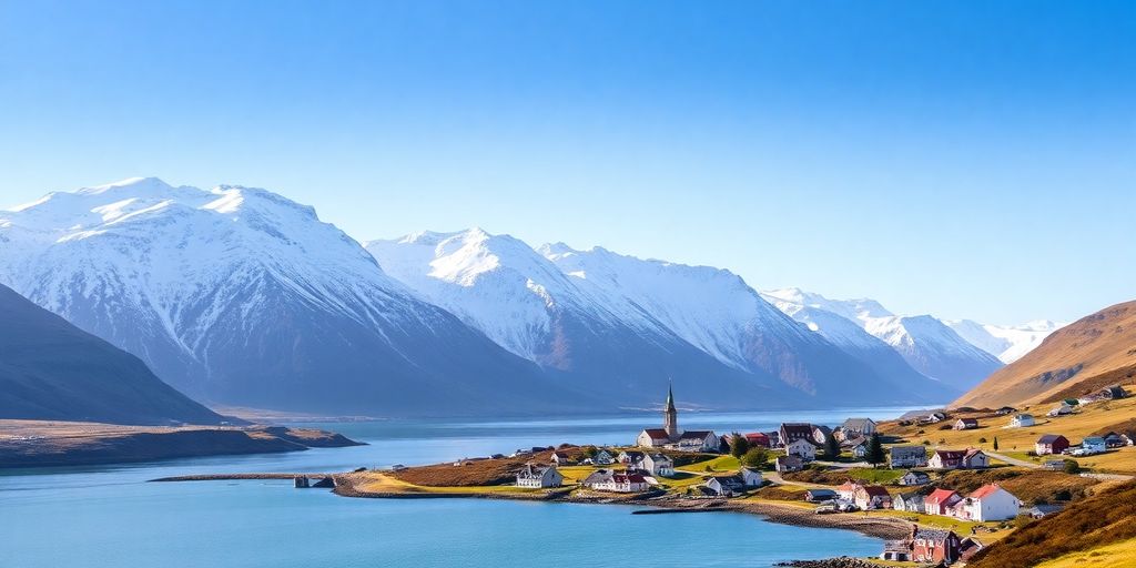 Scenic Dalvik village nestled by a fjord with snow-capped mountains.