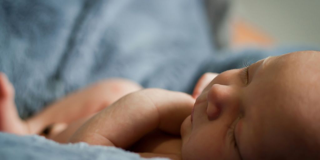 closeup photo of baby on blue blanket
