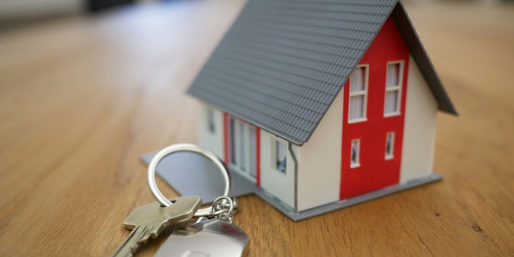 white and red wooden house miniature on brown table