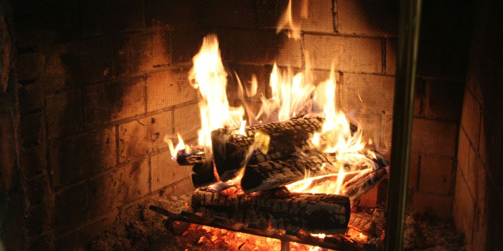a fire burning in a fireplace with rocks and logs