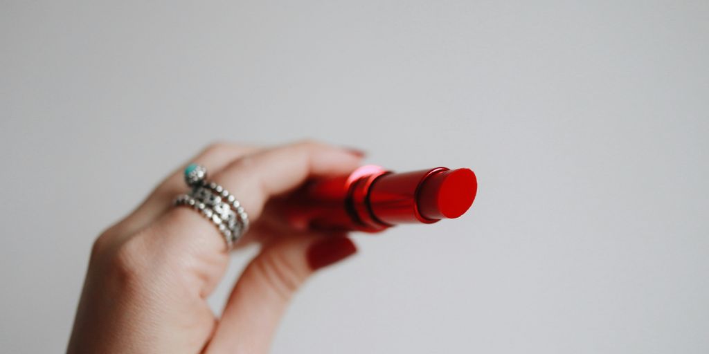 person holding red lipstick