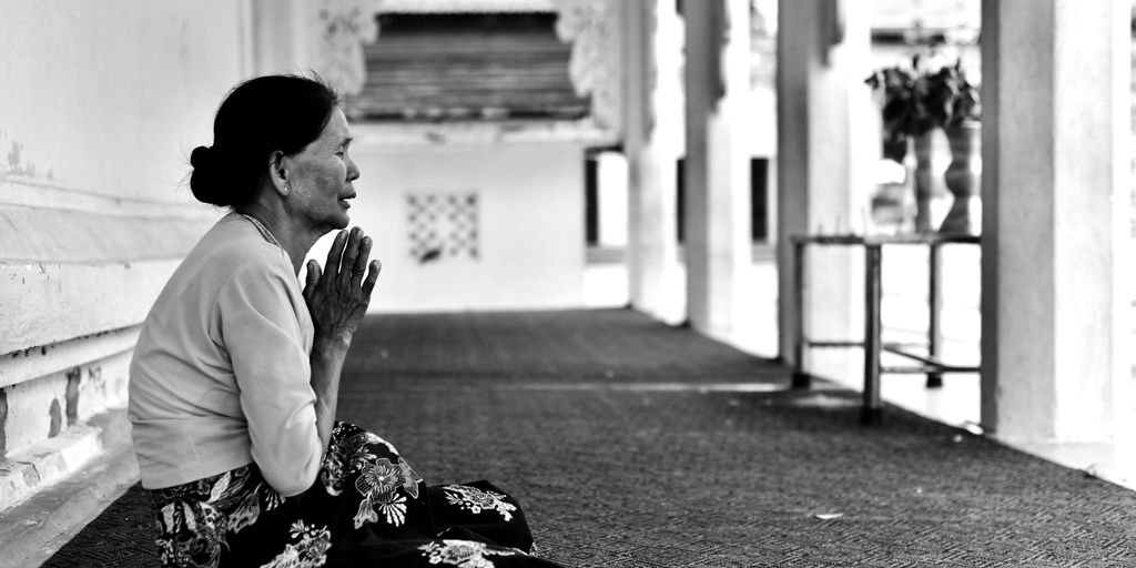 woman praying in grayscale photo