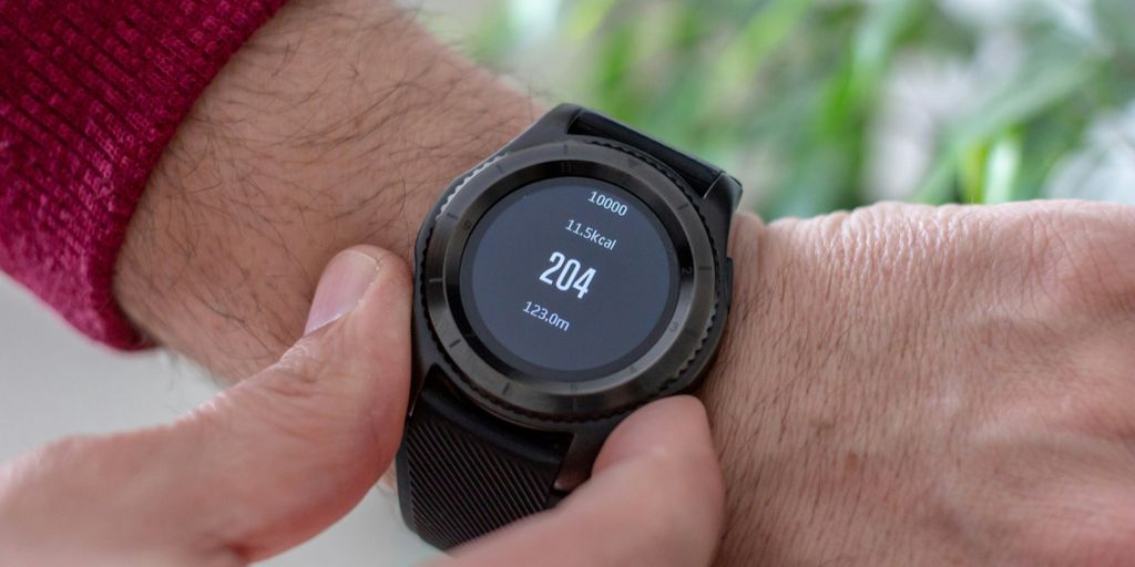 person wearing round black smartwatch