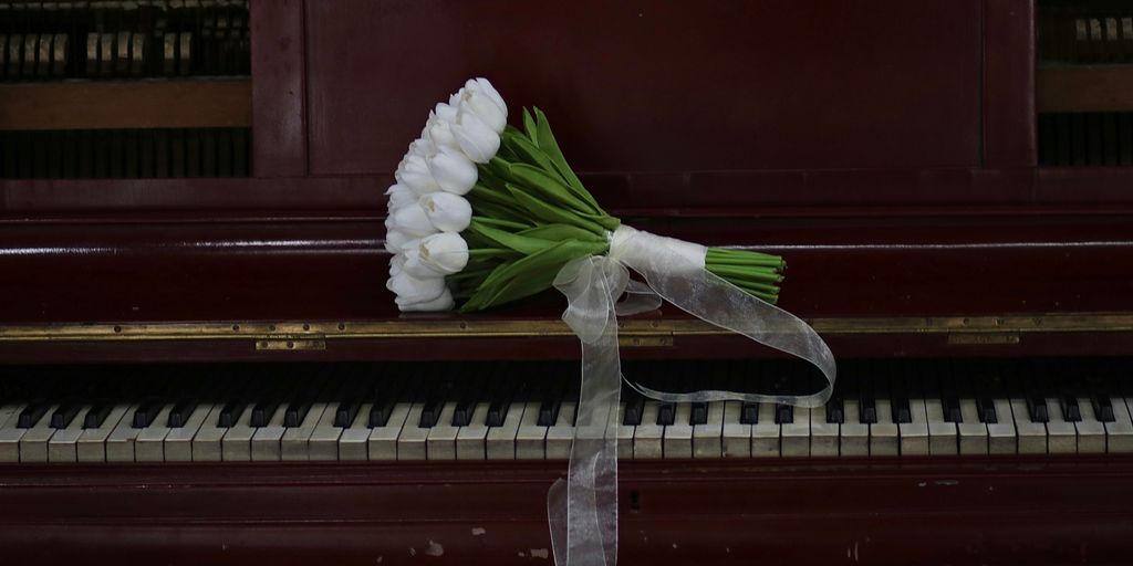 a bouquet of flowers sitting on top of a piano