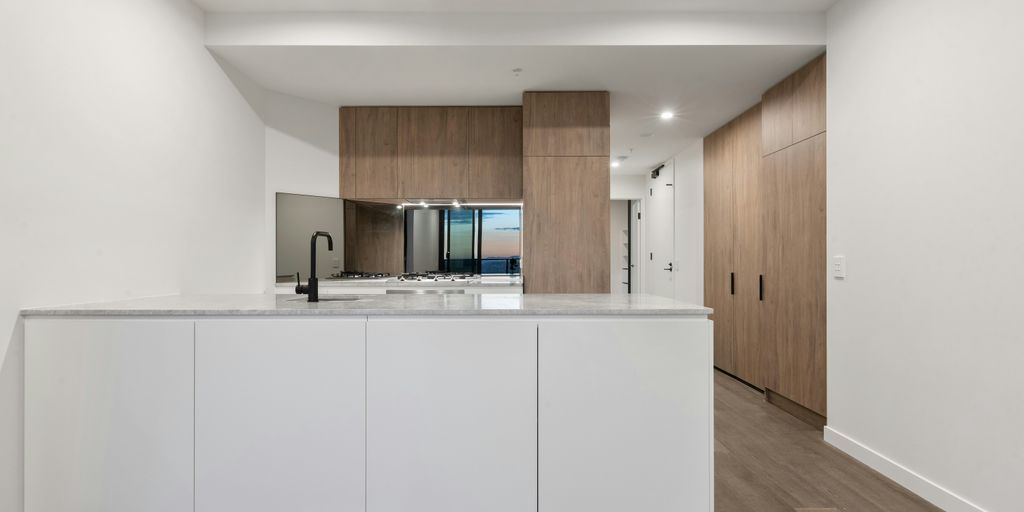 a large kitchen with a white counter top and wooden cabinets