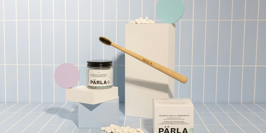 a toothbrush and some pills on a blue tiled floor