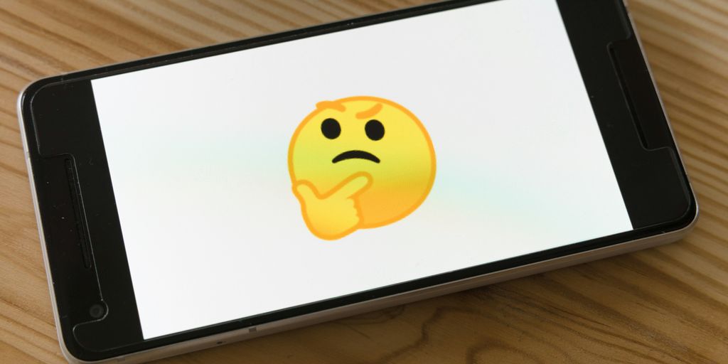black flat screen tv turned on displaying yellow emoji