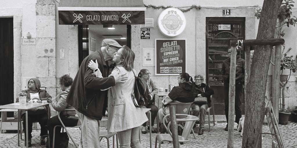 a man and woman kissing in front of a restaurant