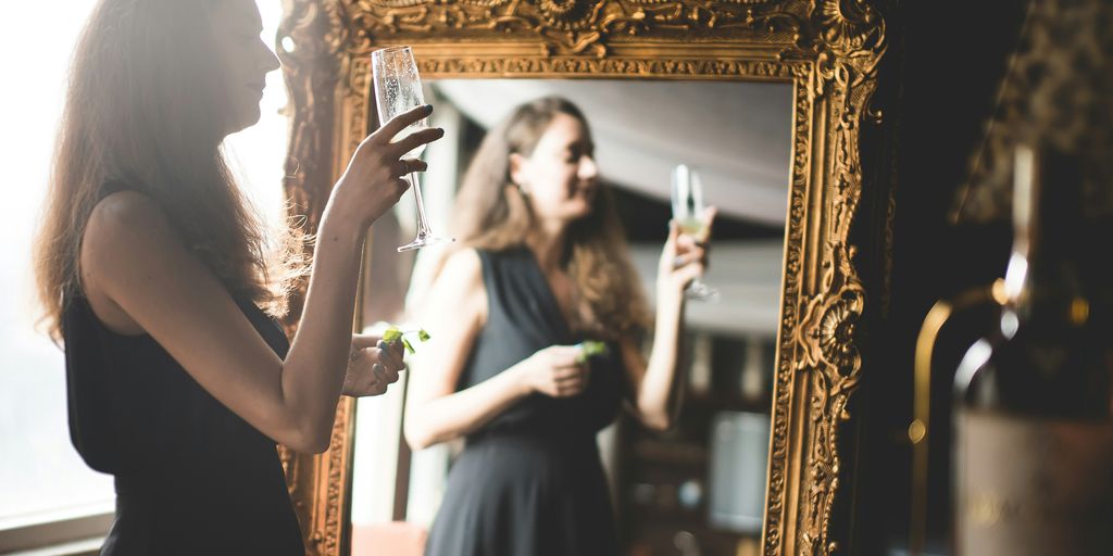 woman standing in-front of brown wooden framed mirror