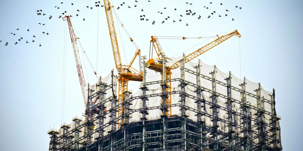 low angle photography of cranes on top of building
