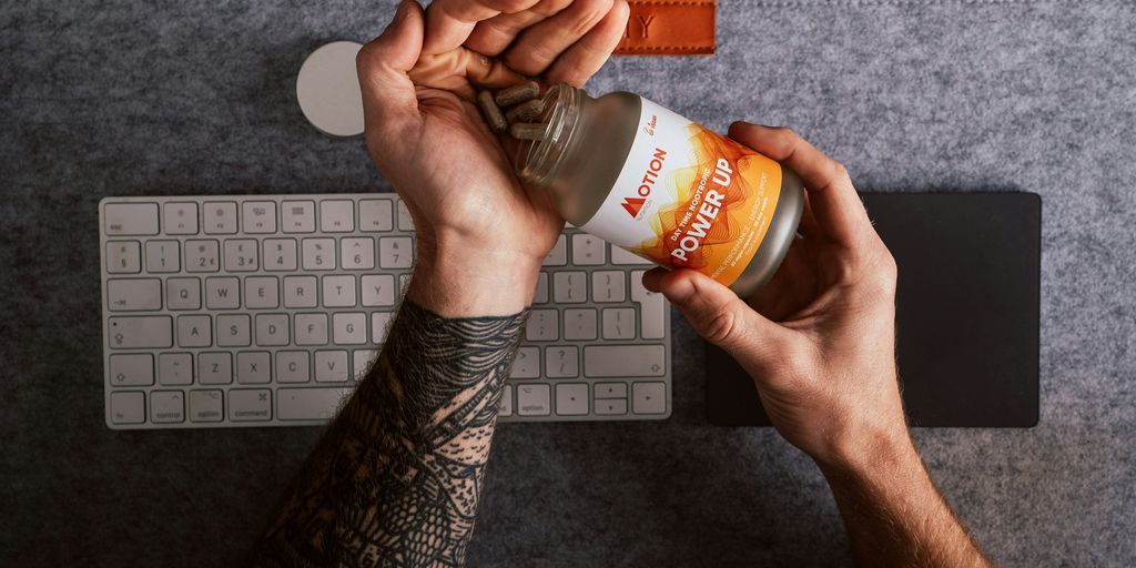 person holding orange and white labeled plastic bottle