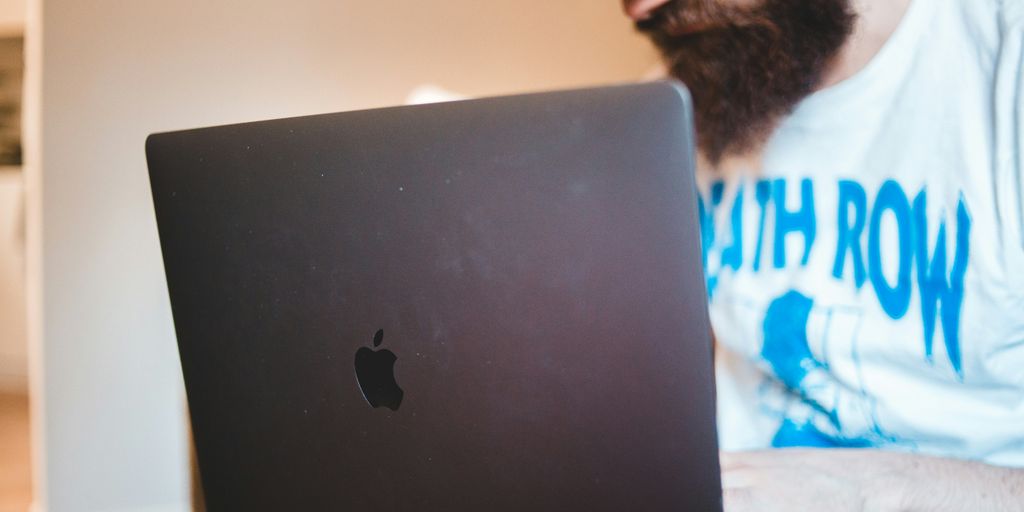 man in white shirt using black macbook Best Keyword Tool for Amazon