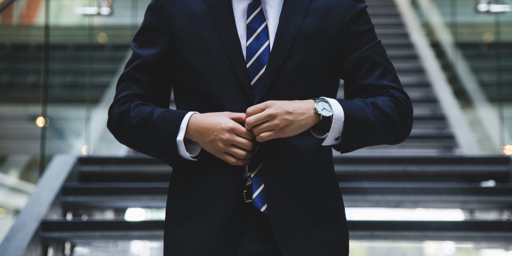 Business professional adjusting suit jacket, symbolizing corporate training readiness and professionalism in virtual environments.