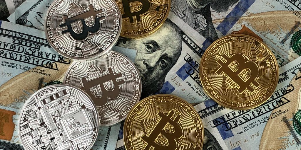 Various cryptocurrencies on top of scattered dollar bills.