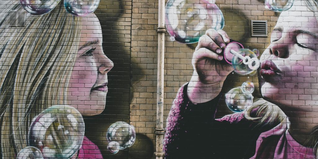 woman in black and pink floral shirt blowing bubbles