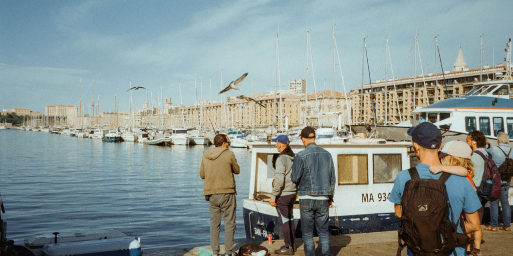 A group of people standing next to a body of water