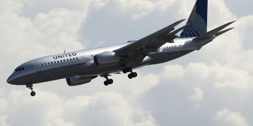 United Airlines plane descending towards a new airport.