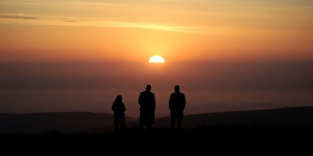 Silhouettes in a serene landscape at sunset.