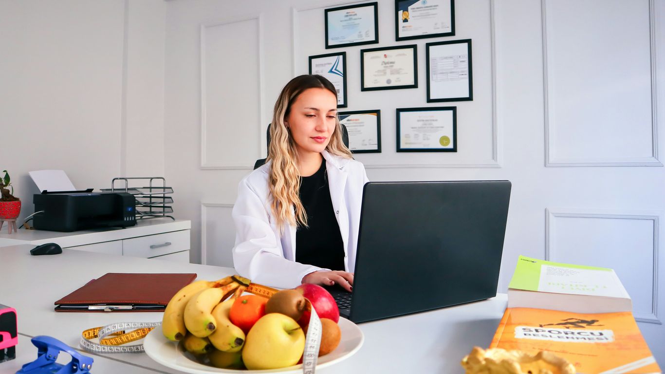 a woman sitting at a desk with a laptop in front of her