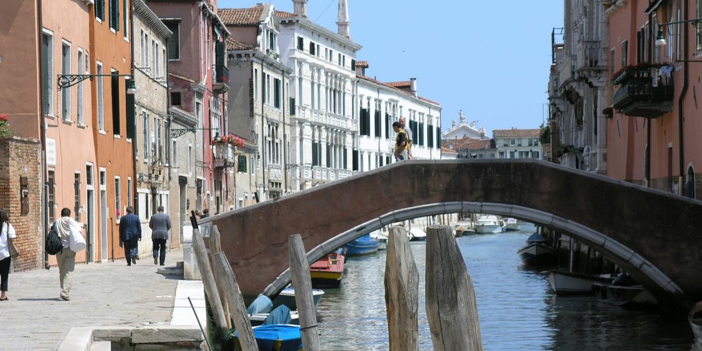 people walking on bridge and near water canal
