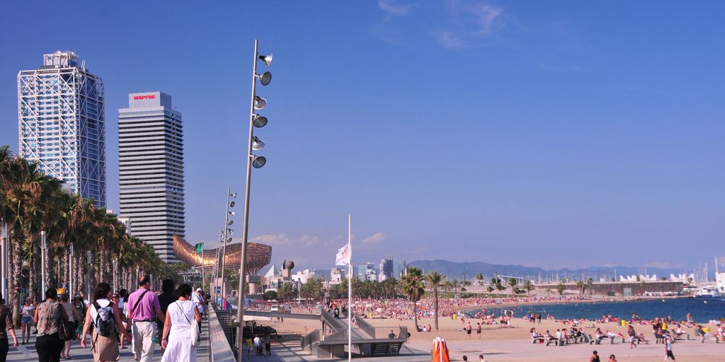 many people are walking on the beach near the water
