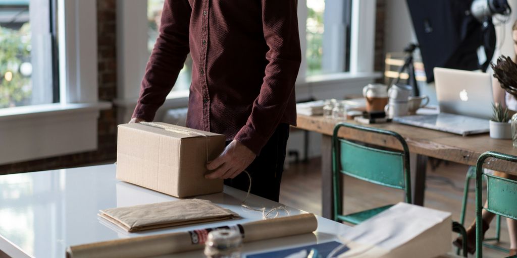 person holding cardboard box on table