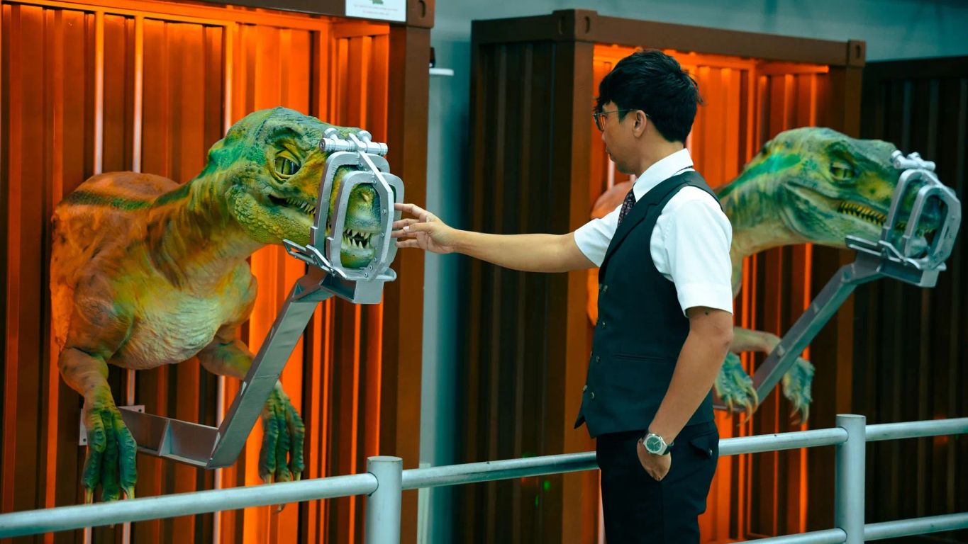 A person interacts with a dinosaur-like creature in a facility.