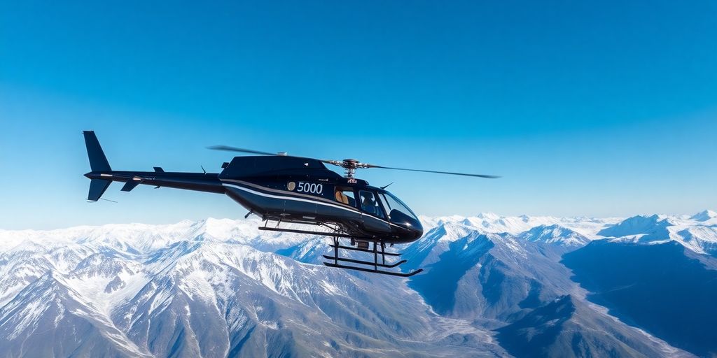 A 500 helicopter flying over snowy Alaskan mountain peaks.