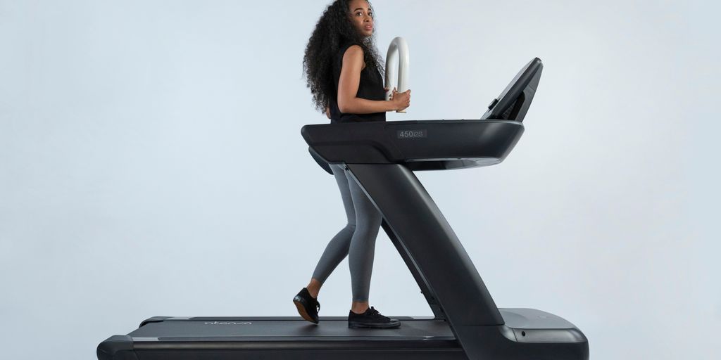 a woman is walking on a treadmill